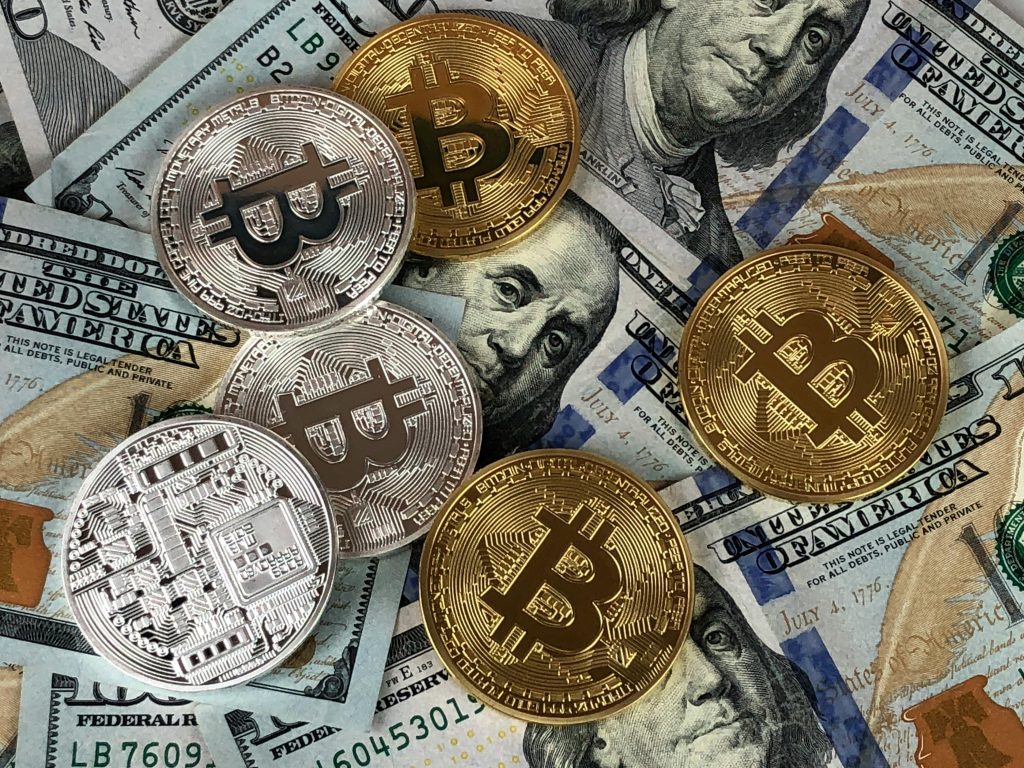 3 Top Money Hacks for 2025: Boost Savings, Invest Smarter, Earn More Close-up of bitcoins and US dollar bills symbolizing modern finance and cryptocurrency.